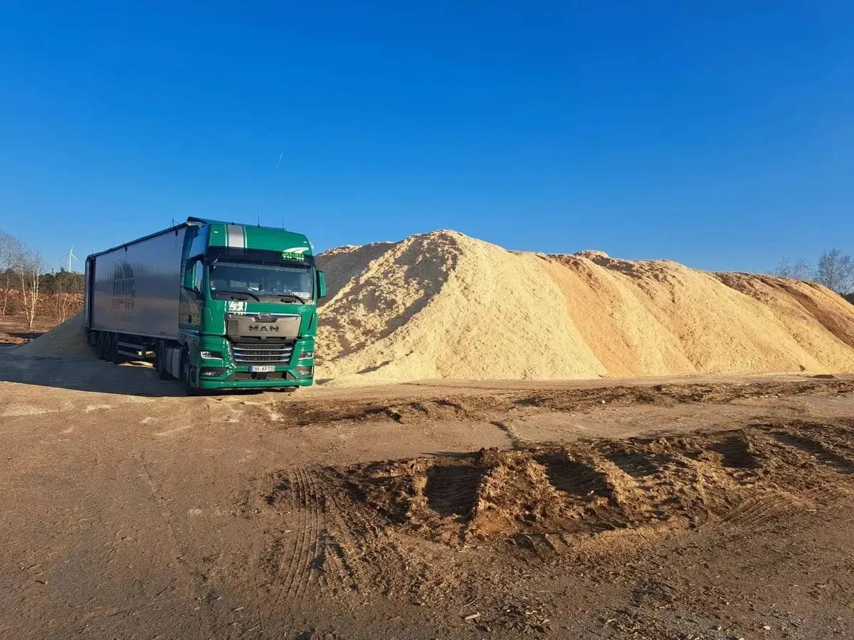 Kolmer-LKW beim Laden von Sägespänen an einer Späne-Halde